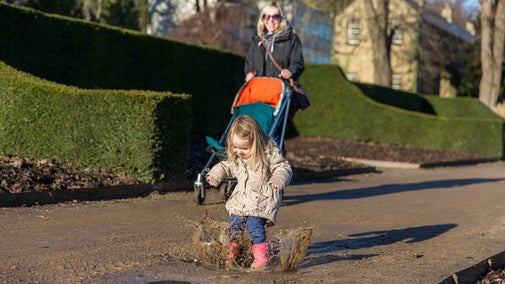 A little girl splashes in puddles at Wentworth Castle Gardens